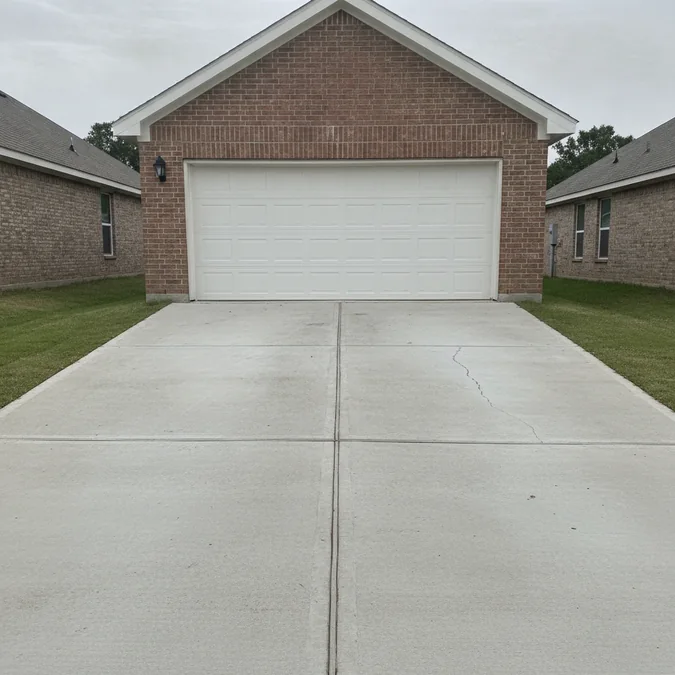 A concrete driveway with a cracked panel at a Forney, Texas home before an estimate.