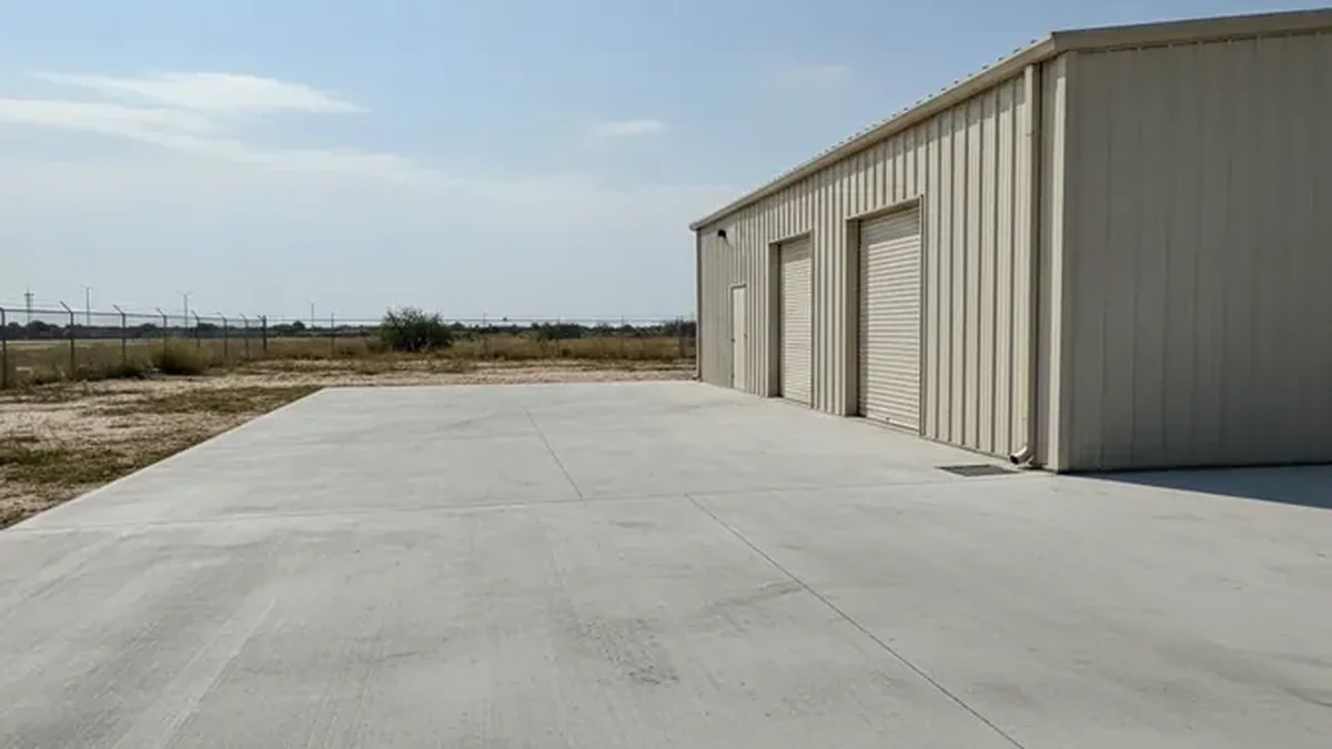 A small commercial concrete parking pad in Mesquite has a broom finish and defined drainage slope.