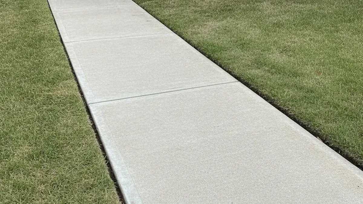A leveled concrete walkway has a smoother transition after the settled panel is raised.