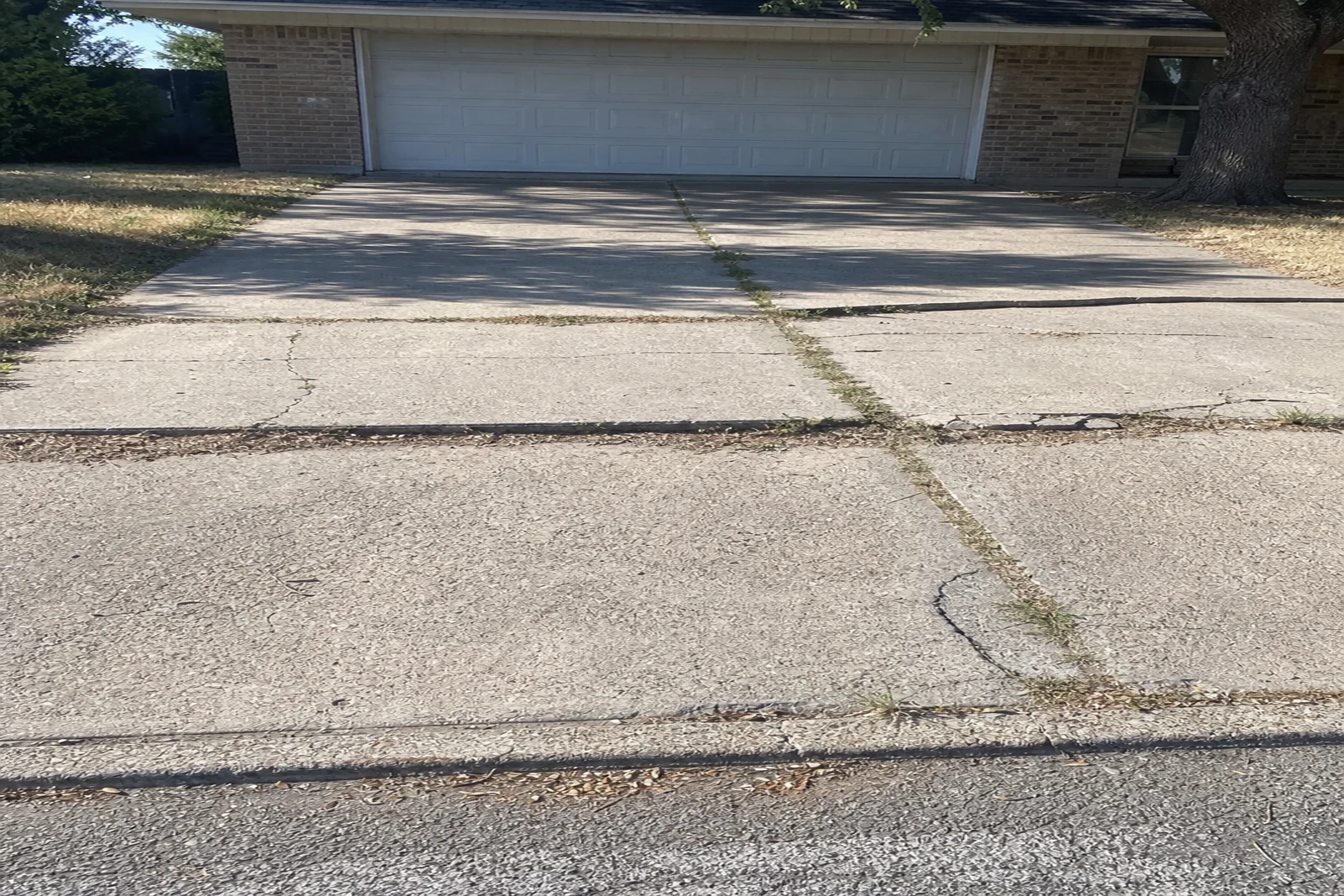 Black clay soil cracked concrete driveway Mesquite Texas Dallas County gumbo clay shrink-swell drought heaving residential