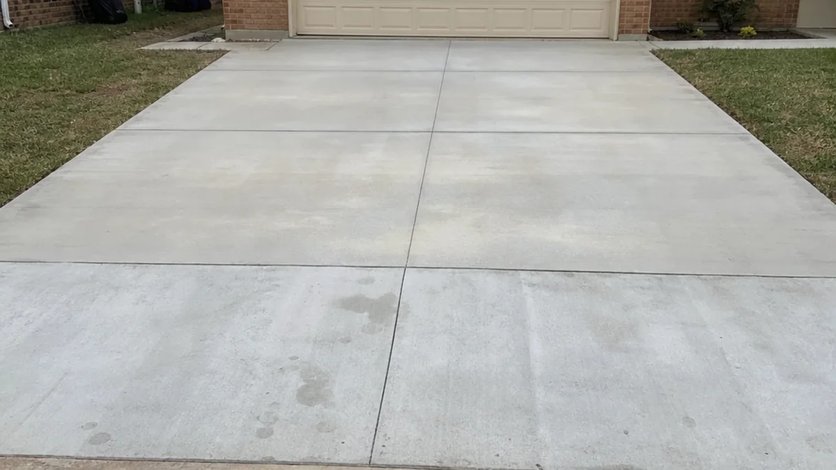 Realistic iPhone photo of finished private concrete driveway Mesquite Texas garage curb apron separate from asphalt street